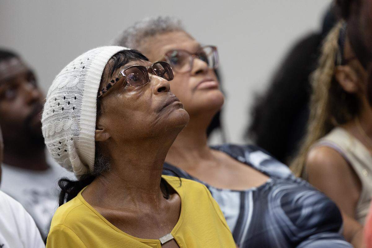 Brenda Hicks stares up at a screen showing meeting minutes at a meeting for East St. Louis District 189.