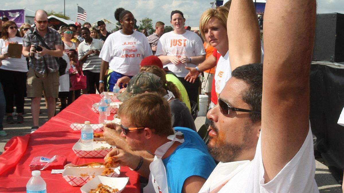 One of the highlights of the Midwest Wingfest is the Wing-Eating Contest. Here, a dozen contestants, 11 men and one woman, gobbled wings quickly to see who could consume 25 chicken wings the fastest, as judges stand over them and check their progress. The Wingfest, which is held on the parking lot of St. Clair Square, helps support disabled veterans.