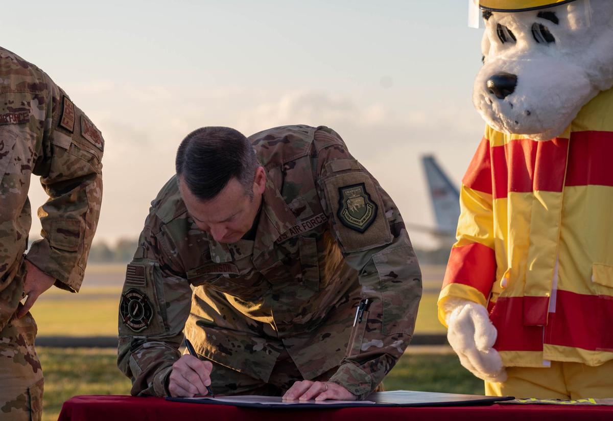 U.S. Air Force Col. Chris Robinson, Air Mobility Wing Commander, proclaims the beginning of Fire Prevention Week by signing proclamation Oct. 6 at Fire Station 1 on Scott Air Force Base. During Fire Prevention Week, children, adults, and teachers learn how to stay safe in case of a fire.