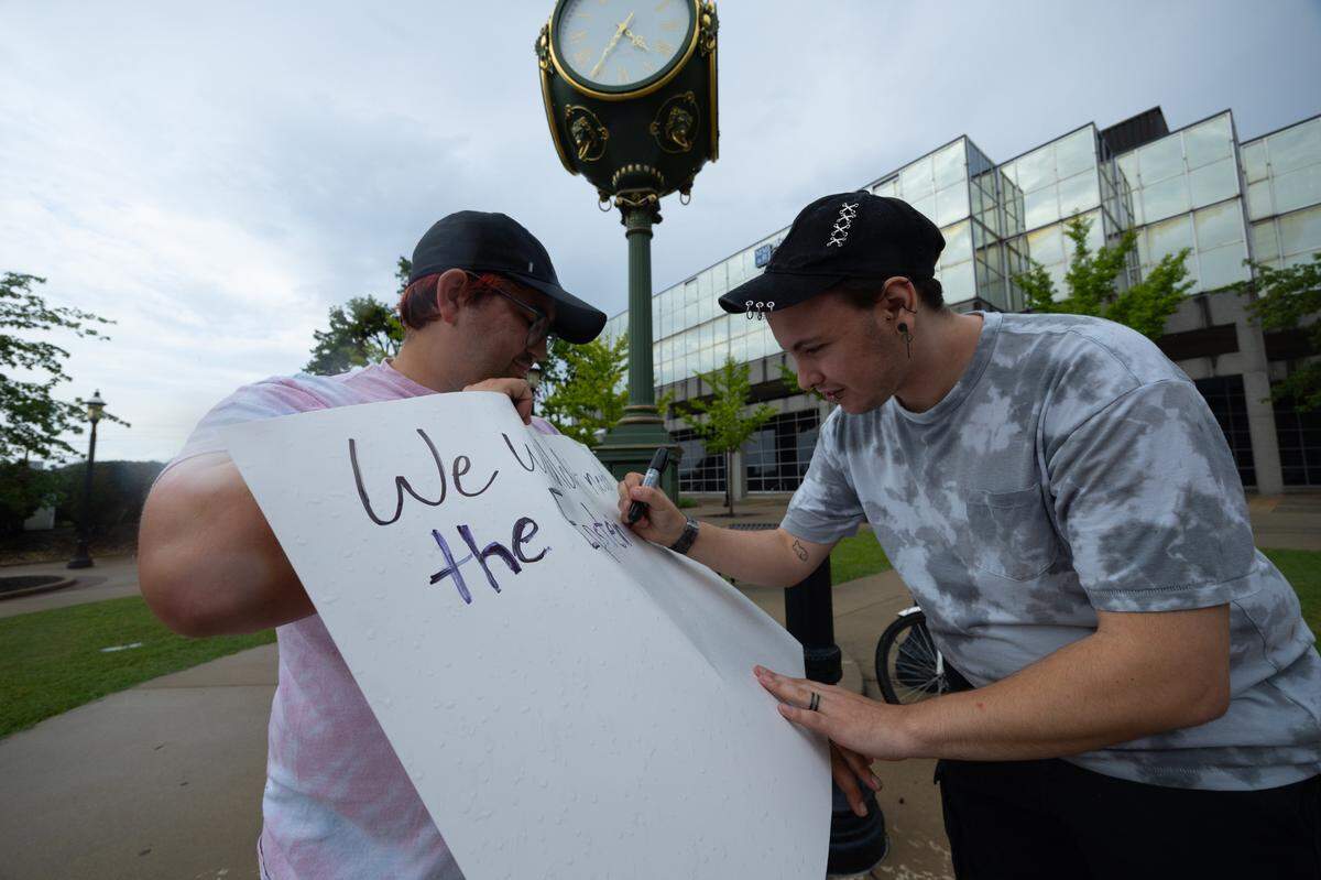 Protestors write slogans on signs before a protest for “good trouble” on John Lewis’s birthday in Belleville.