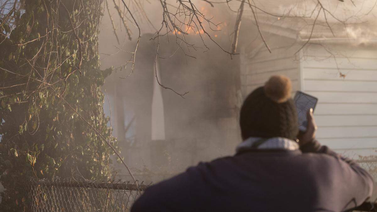 Eddie Hobson calls her landlord as she watches the house that she rents burn to the ground on Thursday in East St. Louis. “We lost everything we had,” said her son Demetrius Hobson.