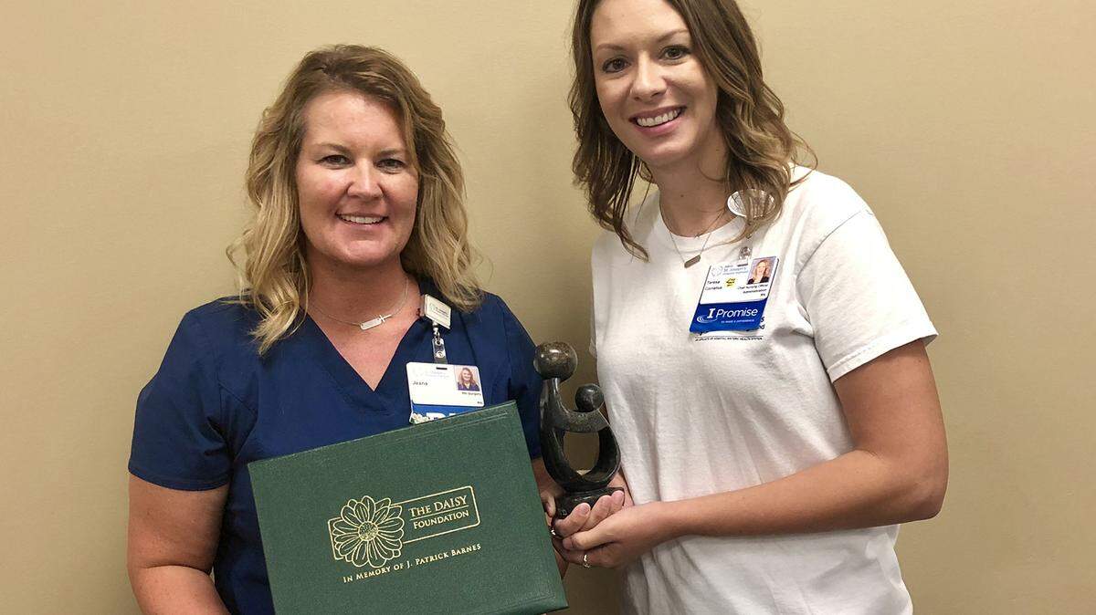 On right, Teresa Cornelius, CNO at HSHS St. Joseph’s in Highland, presents Jeana Olier, RN, (on left) with the DAISY Award.