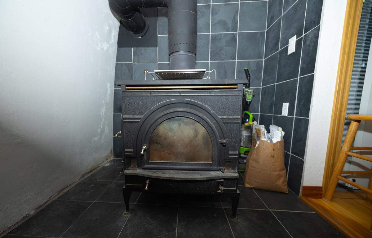 A wood-burning stove (with a glove warmer on top) provides escape from the winter cold with minimal electrical input.