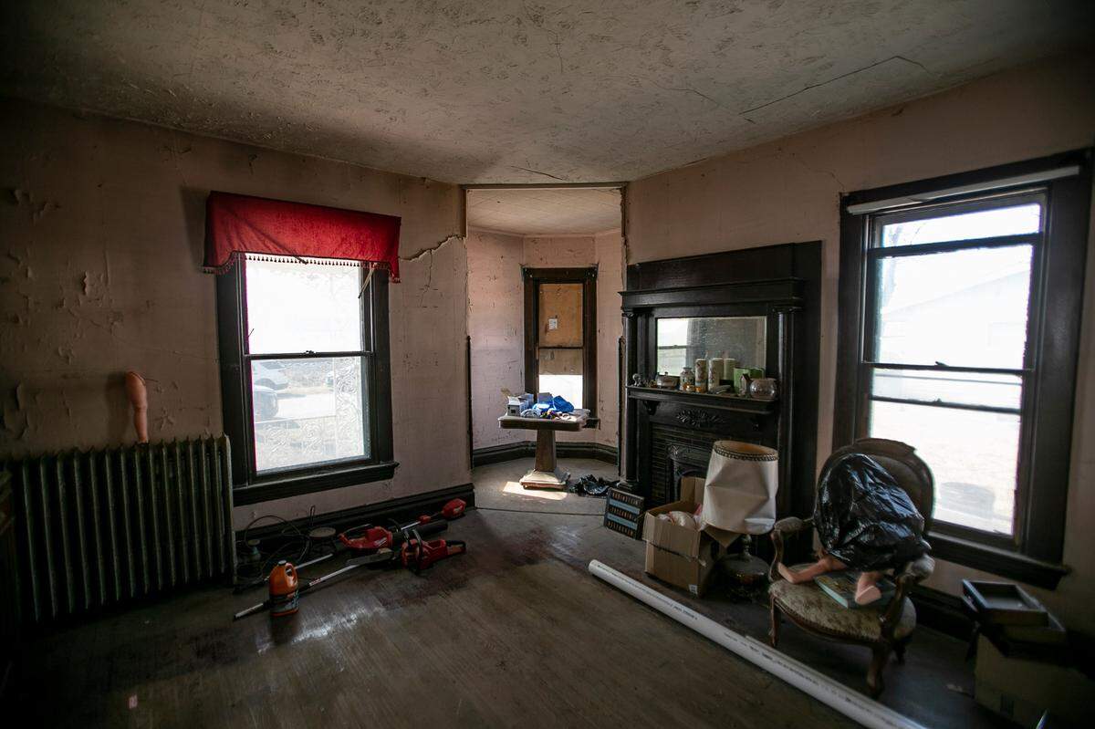 The parlor of “The Pink House” in Aviston has a 10-foot-high ceiling, unpainted woodwork and a decorative fireplace. The room attaches to a small sitting area formed by a round turret.