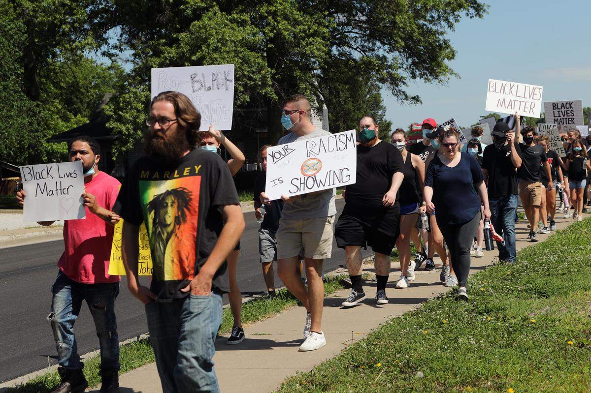 A protester holds an anti-Confederate flag sign at a demonstration Saturday, June 6, 2020, in Freeburg. Earlier in the week, a video of Freeburg Community High School students flying Confederate flags at their graduation parade was shared online.