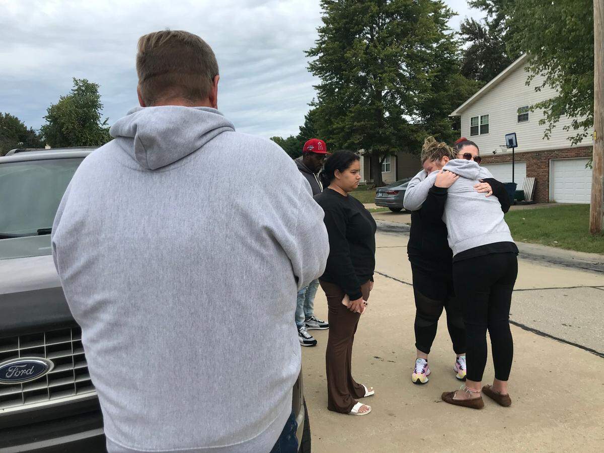 Courtney Tomlinson, right, is comforted by friends and family on Friday outside her duplex on Wood Thrush Street in Troy. Her mother, Susanne Tomlinson, died in a fire across the street on Thursday afternoon.
