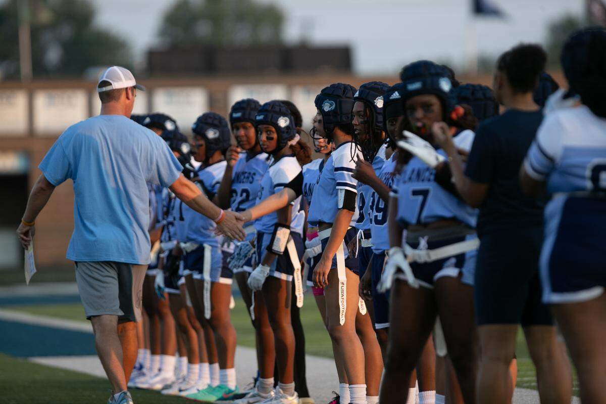 Belleville East Head Coach Doug Zerjal hypes up the girls flag football team for before their inaugural game against the Maroons at Charles Woodford Field on Aug. 28, 2024.