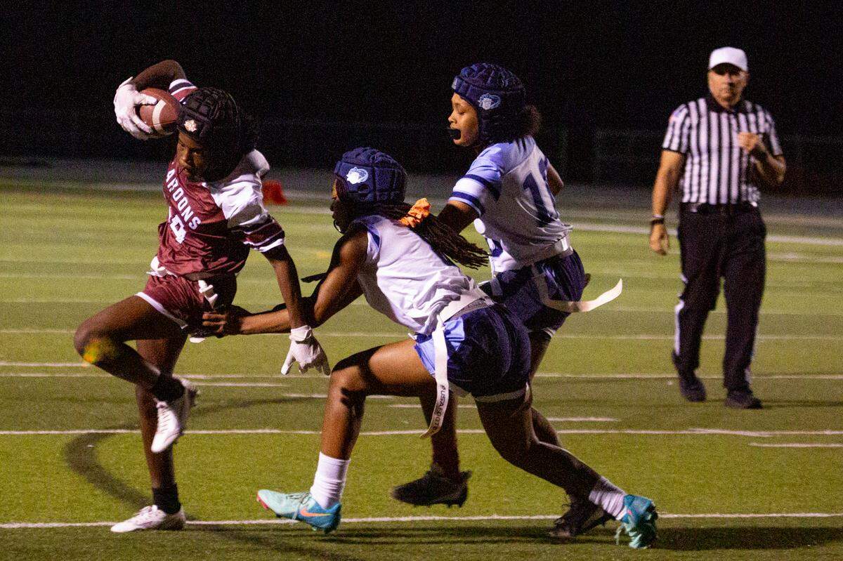 Belleville East’s Yasmin Joseph (8) attempts to rip off a flag belonging to Belleville West’s Amyjia Robinson (84) on Wednesday during the team’s final game of the season at Belleville West High School in Belleville.