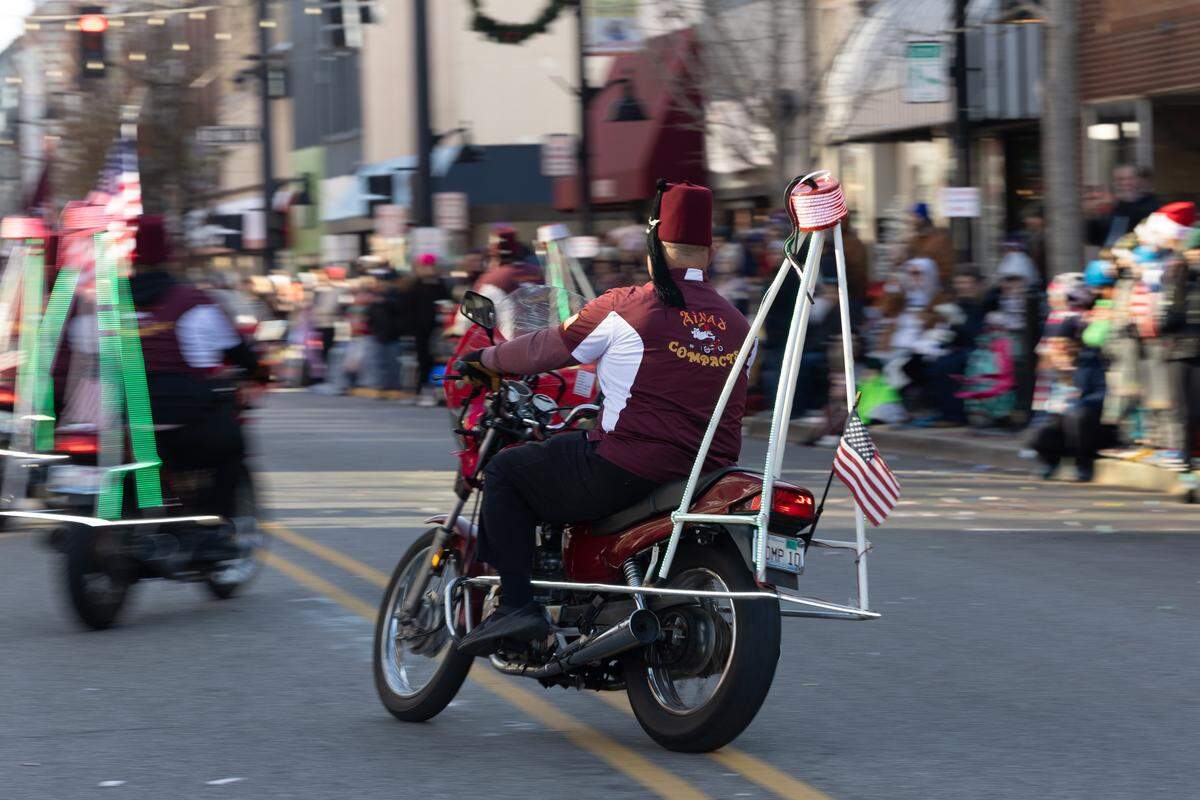Shriners weave in-and-out of formation at high speed as the annual Santa parade moves down Main Street.