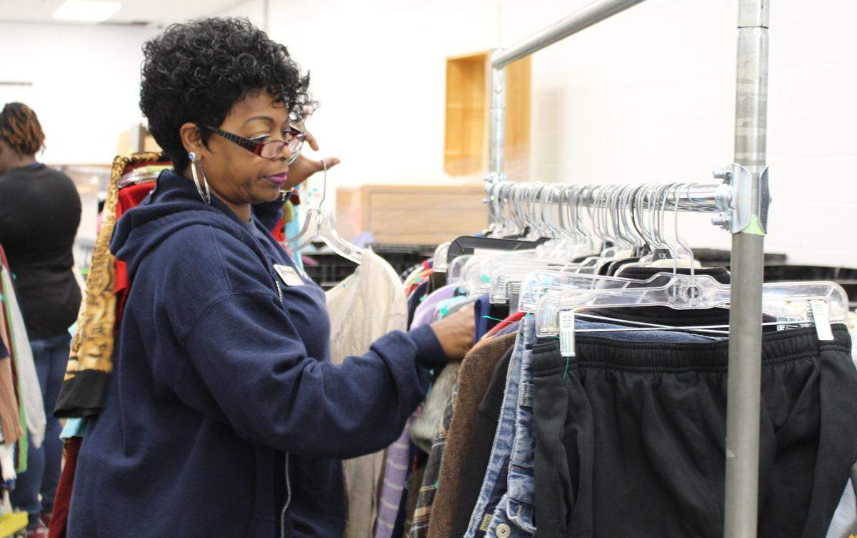 Veronica Wise, an employee at the new Goodwill store in Belleville, sorts clothes and hangs them on racks in the donation-processing center.