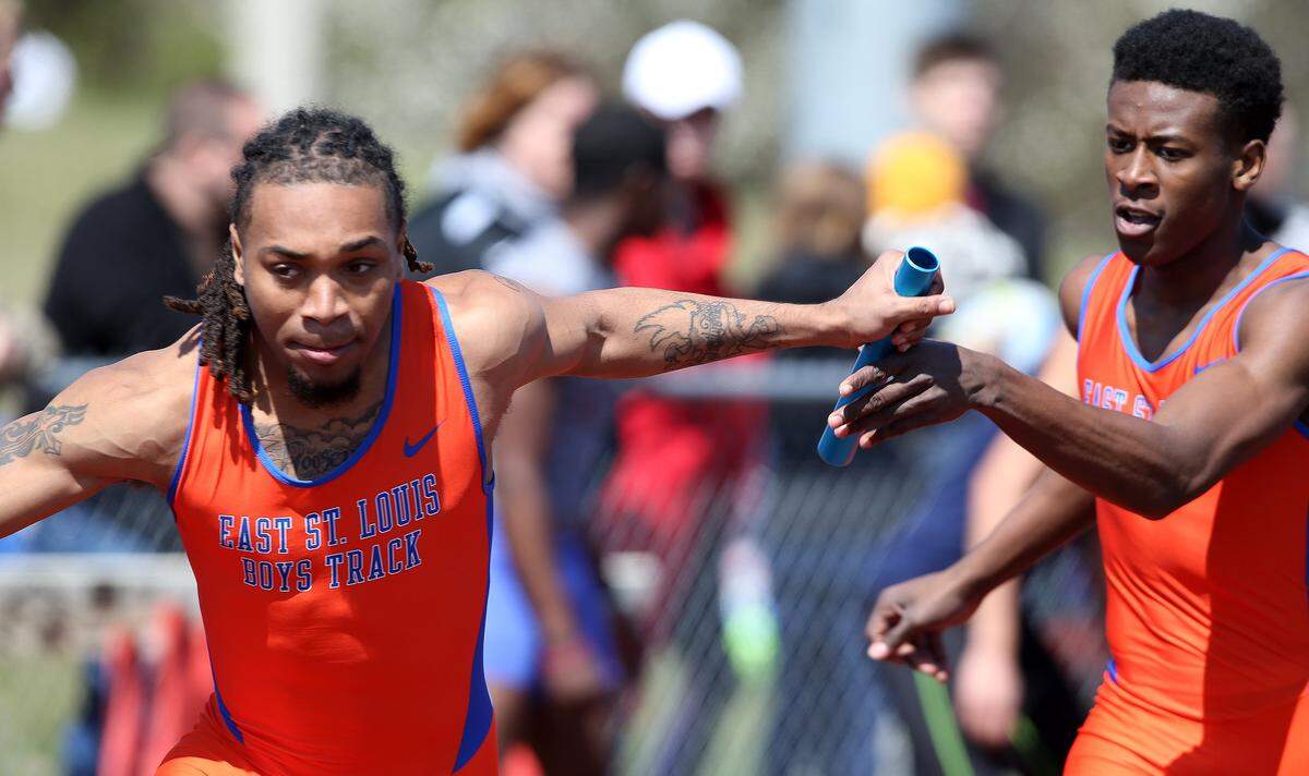East St. Louis' Roosevelt Davis takes the baton from Marlowe Mosley during the 1600 sprint medley relay at the 2016 Southwestern Illinois Relays hosted by Edwardsville high school.