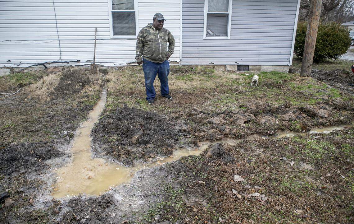 Centreville resident Walter Byrd stands in his side yard next to raw sewage and his attempt to keep the sewage from backing up into his home.