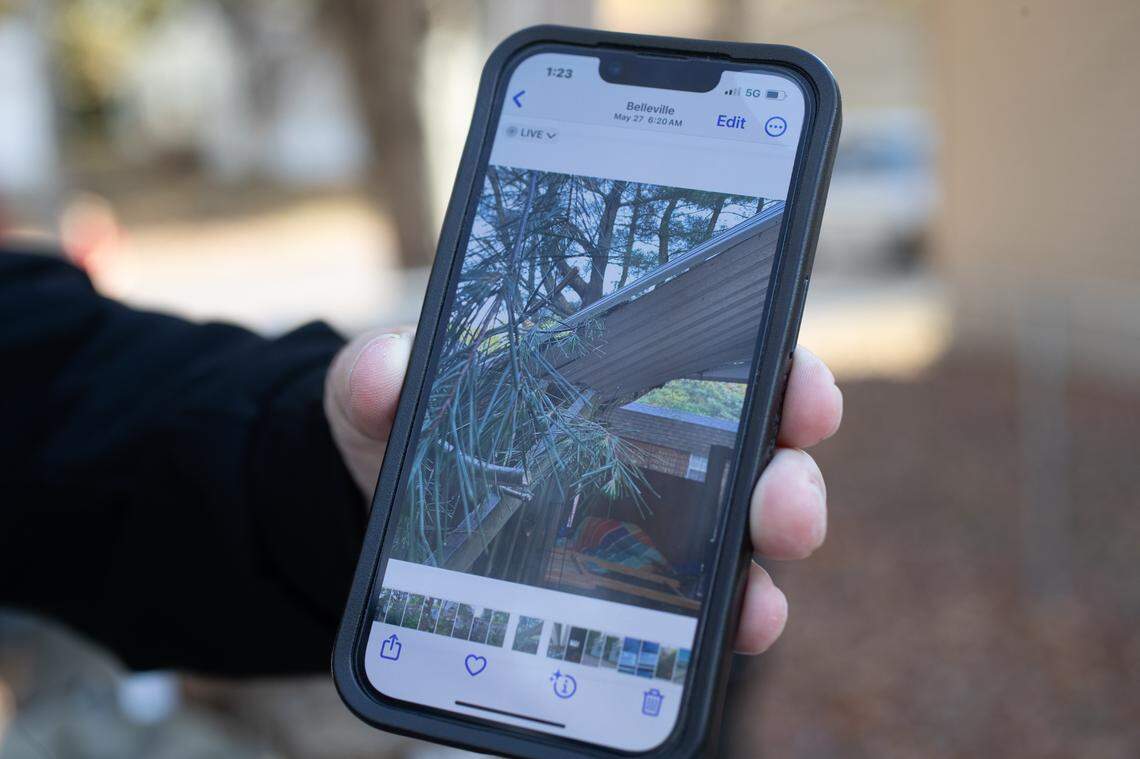 Greenmount Station resident Jim Hodgkins shows a picture of the damaged awning hanging off his rented mobile home from 2024, when a storm caused a tree branch to fall on it.