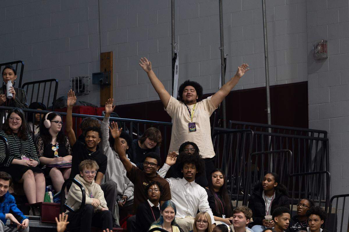 Belleville West students eagerly put their hands in the air to answer civics questions prior to the start of a naturalization ceremony on Friday.