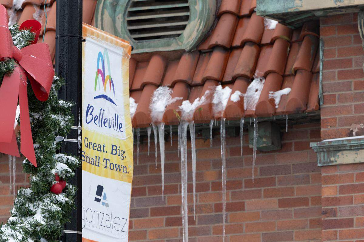 A sign advertising the city of Belleville stands near a snow-covered wreathe with icicles in the background on Jan. 6, 2025.