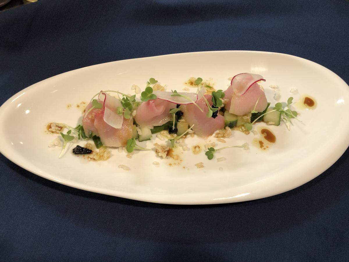 Hamachi Sashimi at Moussalli’s Prime is served with with puffed rice, cucumber, black garlic, white soy, yuzu, radish, sprouts and sesame oil.