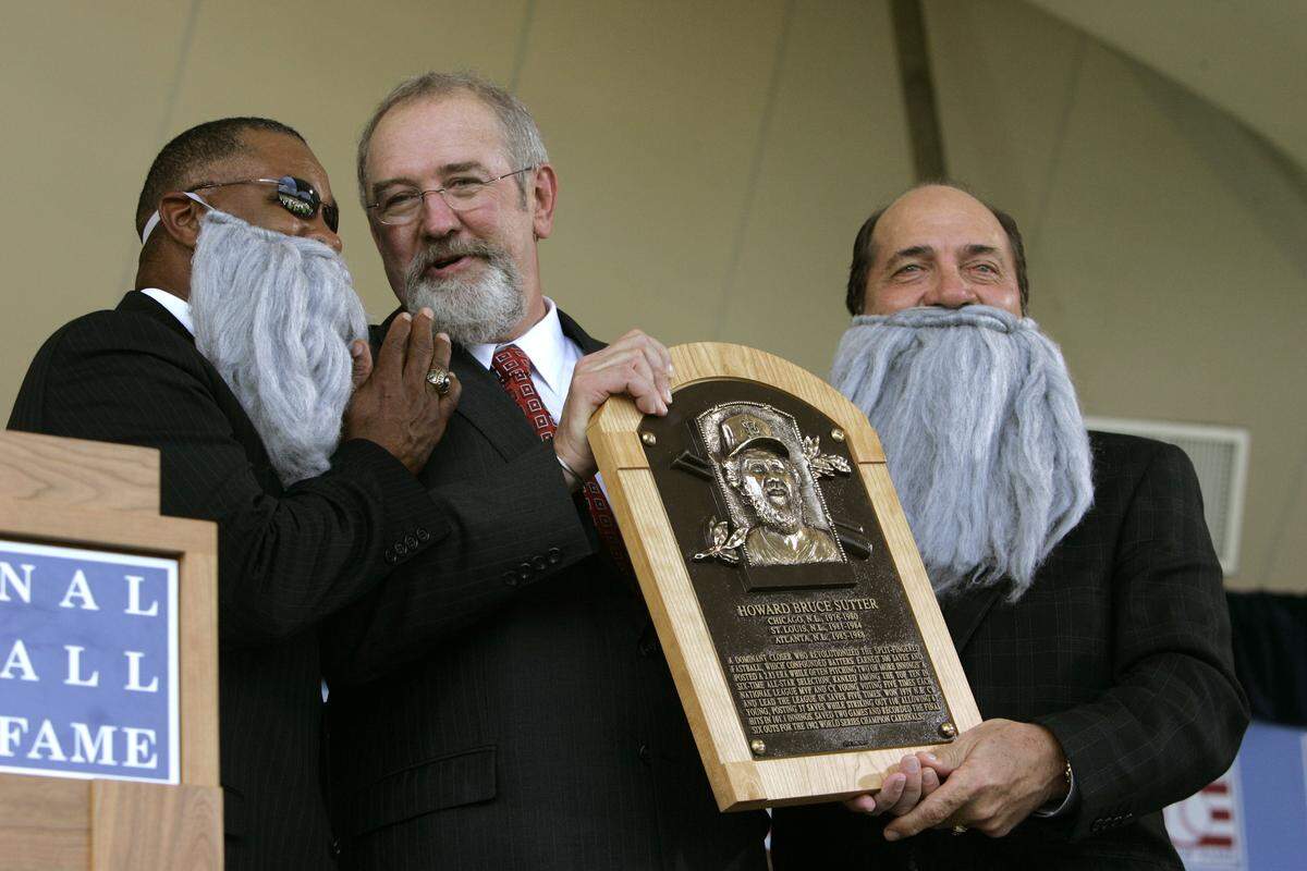 Hall of Famers Ozzie Smith, left, and Johnny Bench, right, help Bruce Sutter during his induction on Sunday, July 30, 2006, at the Baseball Hall of Fame Induction in Cooperstown, N.Y. (AP Photo/ Jim McKnight)