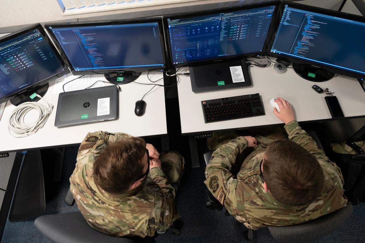 U.S. Air Force Staff Sgt. Jordan M. McClintock, 375th Communications Support Squadron platform architect, right, works through a programming issue with Senior Airman William J. Hartzel, 375th CSPTS application designer, left, on Scott Air Force Base. Members of the 375th CSPTS are continually trained to be programmers beginning with formal training in technical training school, on the job training once arriving at their duty station and are further trained with a company called “Platform One” as they progress within their careers.