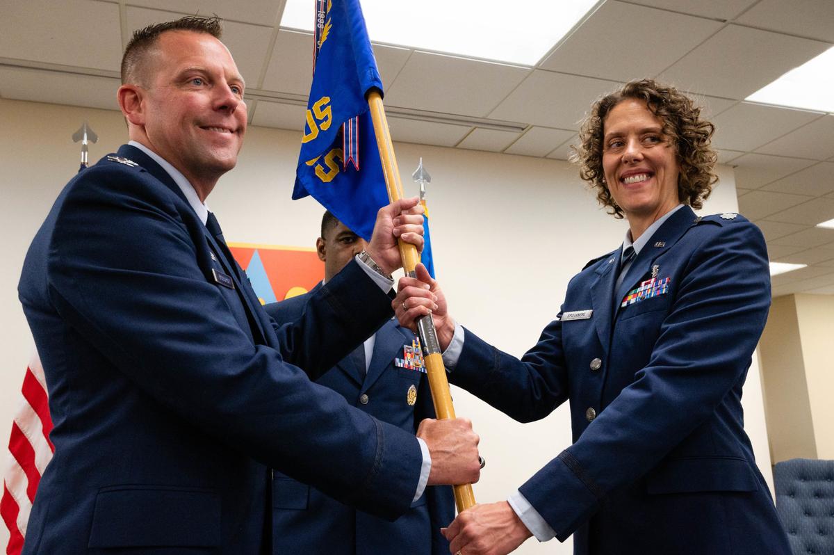 U.S. Air Force Lt. Col. Amy Spotanski, 375th Health Care Operations Squadron commander, accepts the guidon from Col. Richard Woodruff, 375th Medical Group commander, during a change of command ceremony at the Deltgen Auditorium on Scott Air Force Base. The 375th HCOS provides mission support to Scott AFB enabling mission readiness.