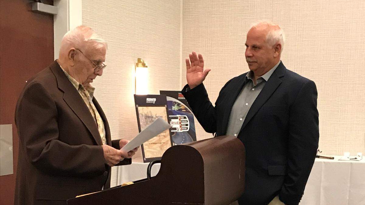 Mike Ehret is sworn into the office of president of the Illinois Association of Plumbing, Heating, Cooling and Mechanical Contractors by his father, Grant Ehret.