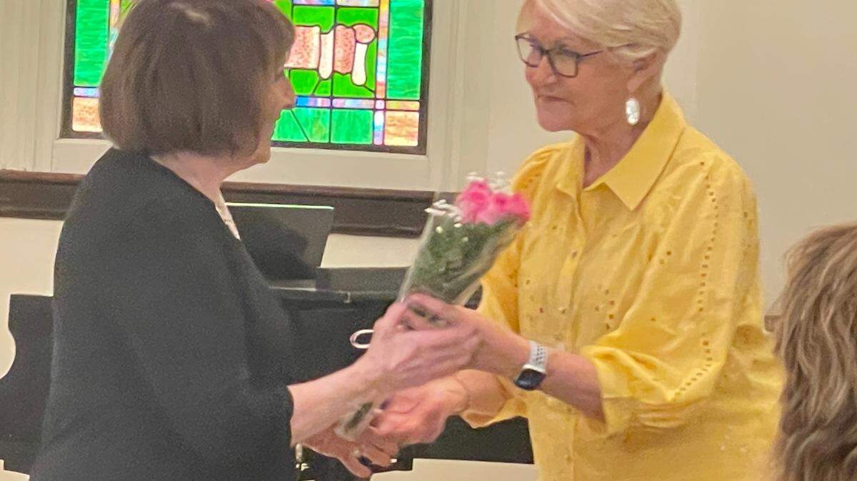 At the final meeting of the St. Clair Women’s Club, member Judy Pratl presents third-generation president Ann Smith with a rose and a hug.