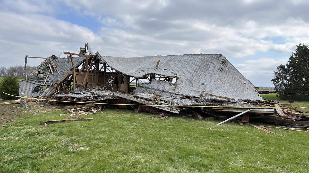 A barn north of Waterloo partially collapsed and caught fire on Saturday morning as three workers were tearing it down. One of them died.