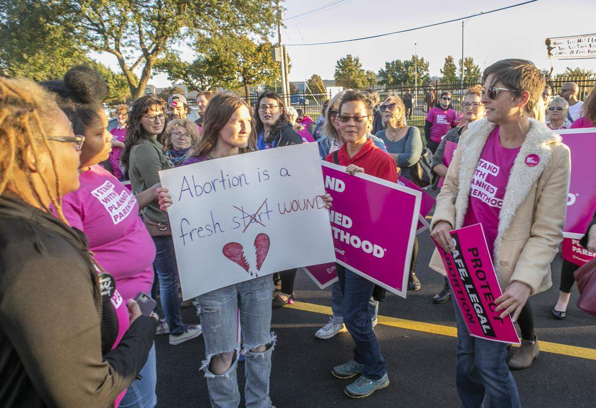 A anti-abortion supporter is surrounded by Planned Parenthood supporters after she walked onto the property of the new Planned Parenthood clinic in Fairview Heights.