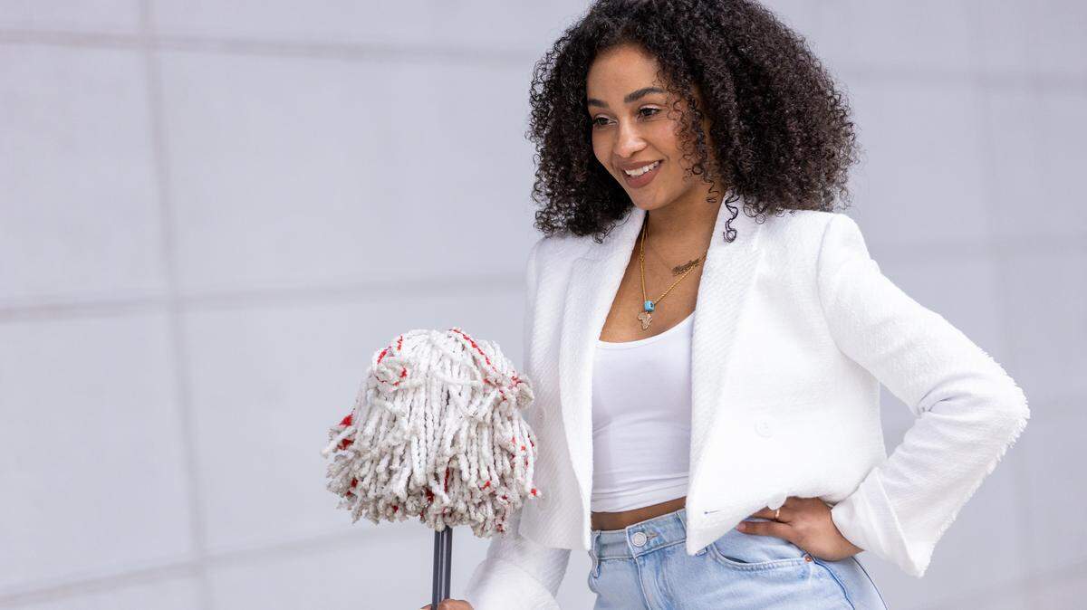 A woman holding a mop.