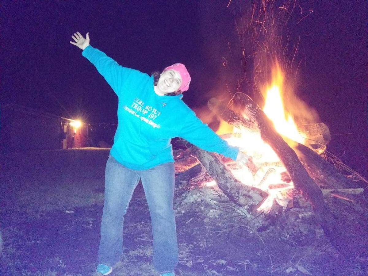Amy Huller, leader of Belleville Troop 497, has fun with Girl Scouts around a campfire at Camp Chan Ya Ta near Worden in the mid-2010s.