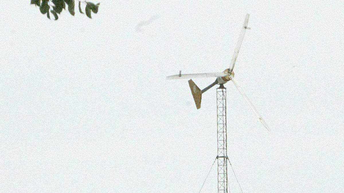 A wind turbine spins in the breeze on Monday at a farm along Buffalo Road, north of Highland. Residents in the city of Highland who produce their own green energy, whether it be from wind or solar, will now have to pay a $25 monthly fee if they wish to receive a rebate from the city for excess power they produce that is pushed back onto the city’s electric grid.