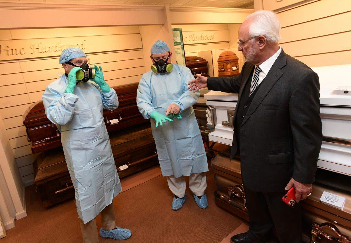 From left, funeral director assistant Jim McCruary and funeral directors Daniel Kovacs and Bill Harris discuss COVID-19 precautions at Harris Funeral Home in Johnstown, Pennsylvania, on Thursday.