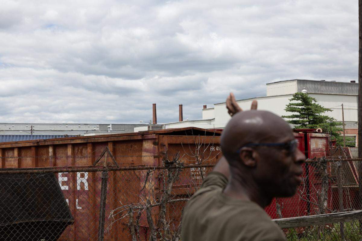 Calvin Ratliff points toward the factory where radioactive elements were once processed next to his childhood home in Venice, Ill., on June 10, 2024.