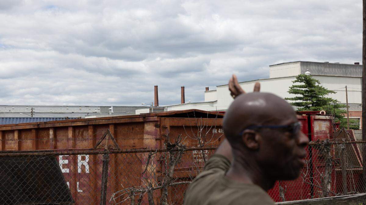Calvin Ratliff points toward the factory where radioactive elements were once processed next to his childhood home in Venice, Ill., on June 10, 2024.