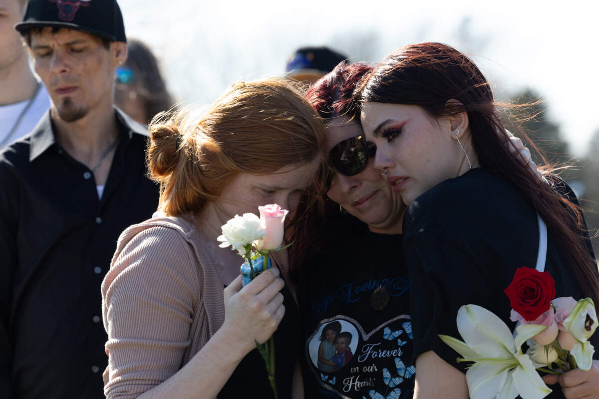 Family of Sharli Edmonds and Chad Metcalf, who died in a house fire Feb. 24 in Cahokia Heights, Ill., find comfort in one another while the casket is lowered at Cedar Hill cemetery in Cedar Hill, MO.