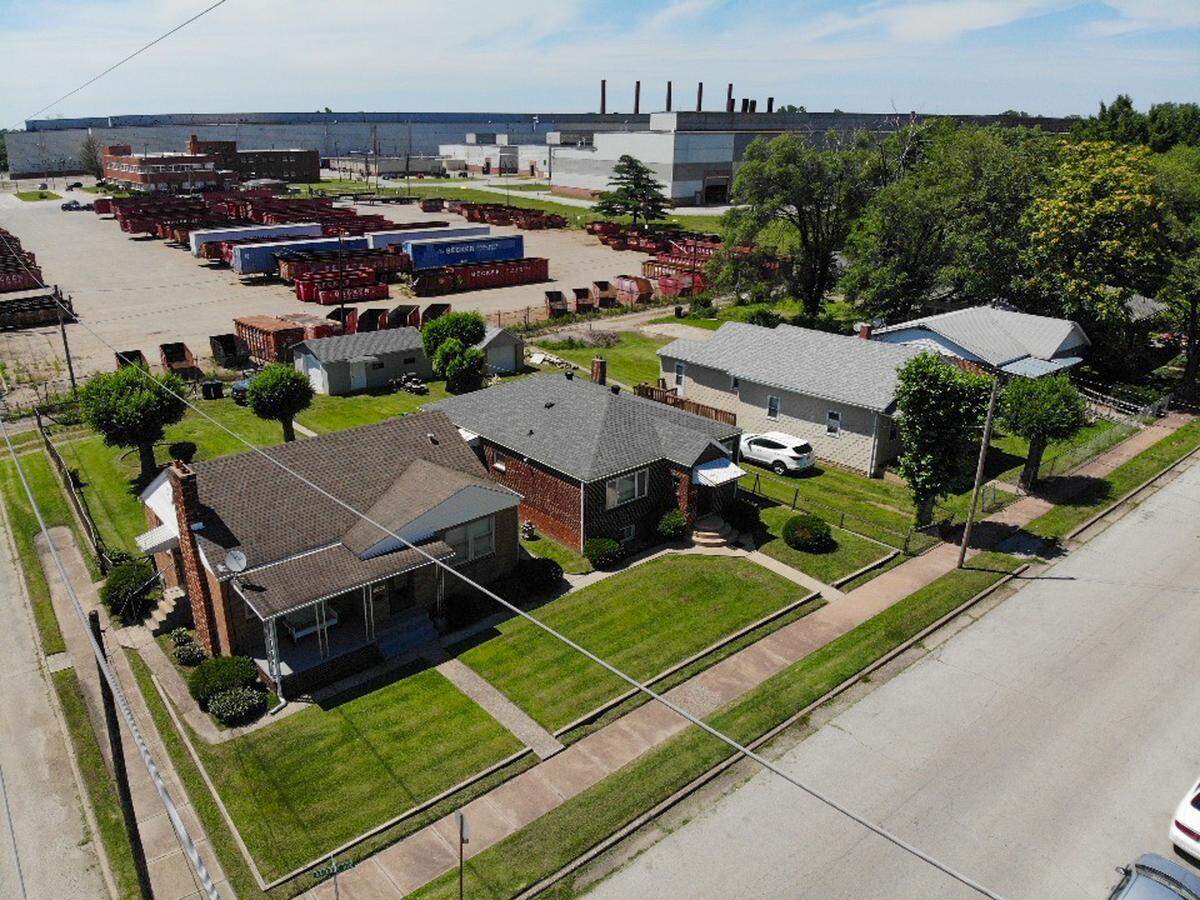 The Ratliff family house sits in the far-left front of the photo and in the background a heavy metal chemical facility stands on Tuesday, June 11, 2024, in Madison, Ill.