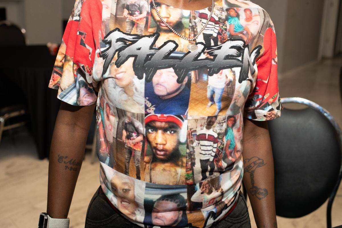 Laticia Simms wears a shirt showing people close to her who have died as victims of crime.