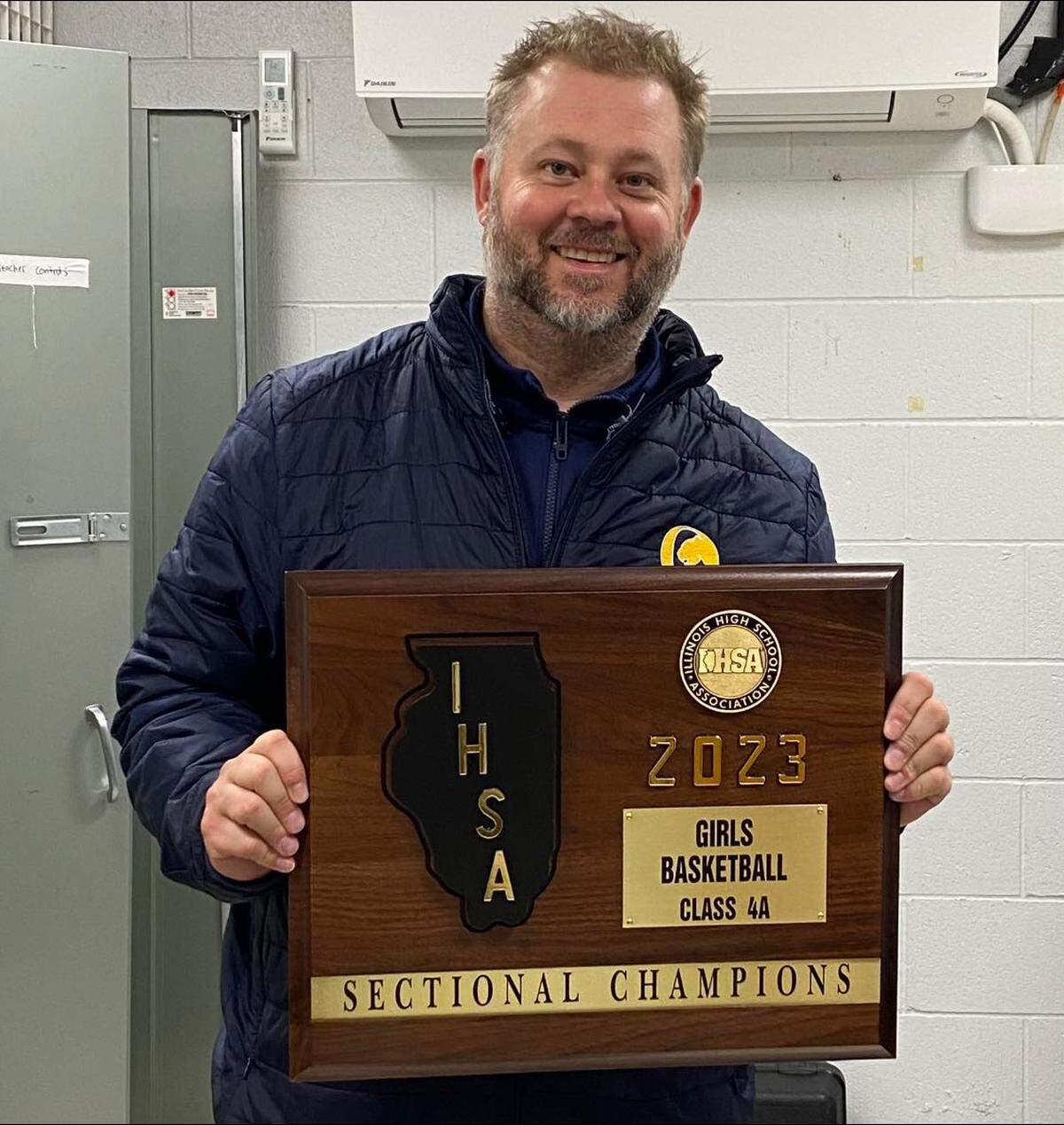 O’Fallon coach Nick Knolhoff displays the sectional championship plaque following his team’s 60-42 win against Normal Community at the IHSA Class 4A O’Fallon Sectional. The Panthers improved to 31-4 on the season.