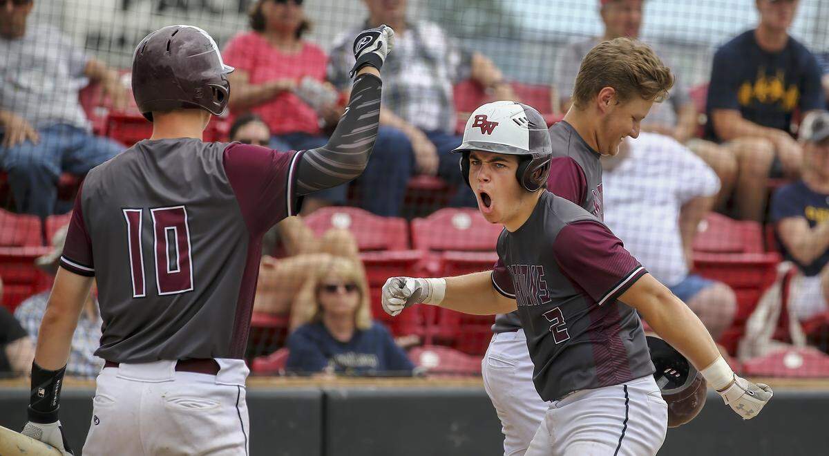 J.B. Bierman (2) is congratulated by Connor Adams after hitting a home run in the second inning during Saturday’s regional championship game at Granite City High School.