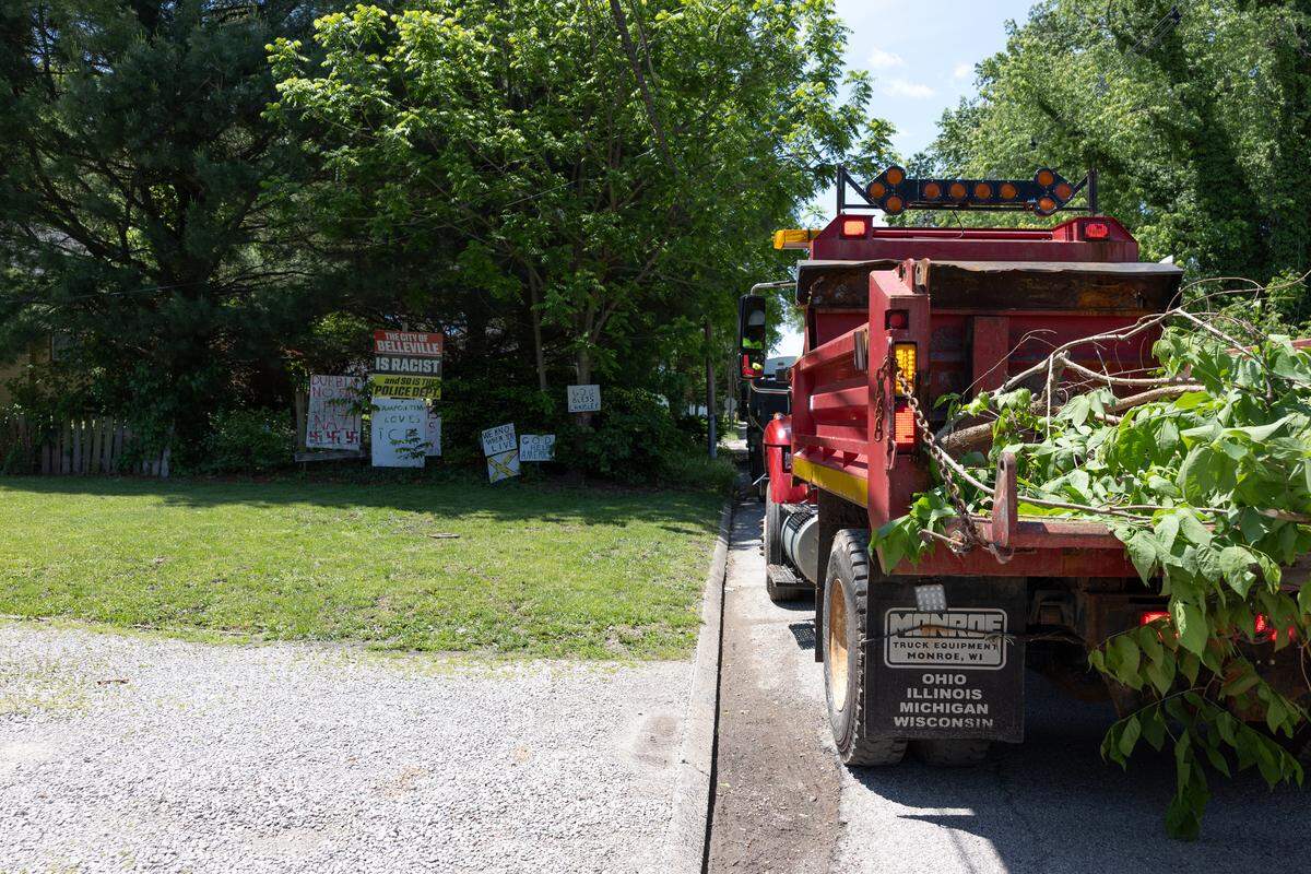 A Belleville public works truck sits outside the home of Stewart Lannert on Thursday afternoon on South 29th Street. City workers were filling it with overgrown grass and weeds, brush and saplings that they had cut.