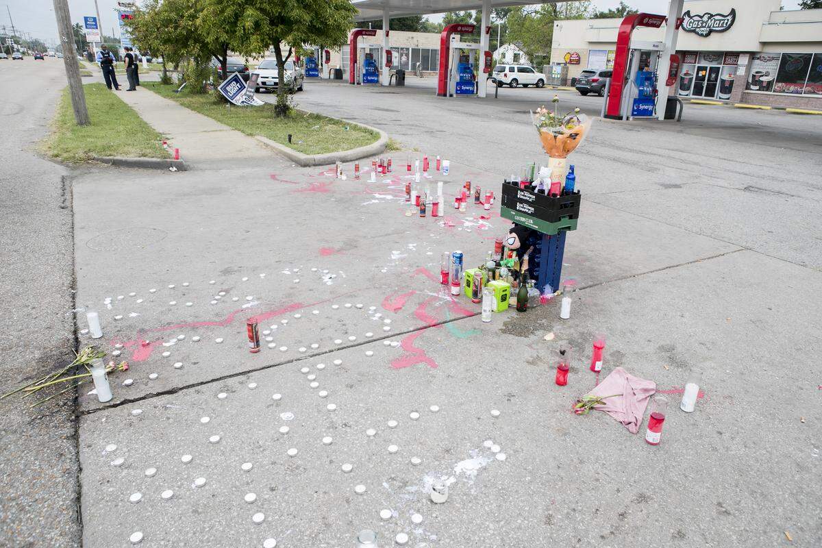 Several Illinois State Police troopers talk near a memorial for East St. Louis rapper Cedric Gooden, also known as Cold Kase. Gooden was shot and killed about 9:50 p.m. Monday in the parking lot of the Gas Mart at 84th and State streets in East St. Louis. Illinois State Police were in the area on Tuesday continuing the investigation of the murder.