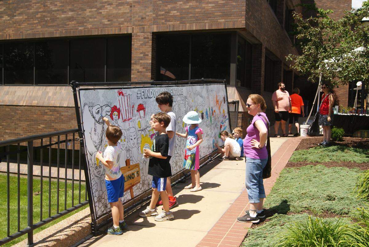 Children contribute to a mural during Art on the Square in downtown Belleville last year. The show also includes the work of more than 100 professional artists from all over the country.