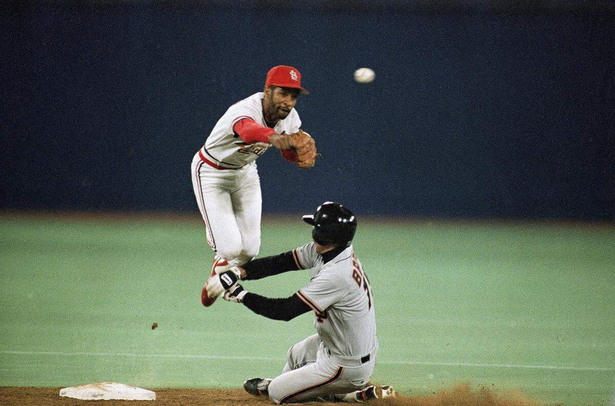 St. Louis Cardinals Ozzie Smith turns a fifth inning double play on a ball hit by San Francisco Giants Chris Speier as Giants Bob Brenly makes a vain effort to break up the relay throw in the seventh game of the National League Championship Series at St. Louis Busch Stadium on Wednesday, Oct. 14, 1987. Smith was involved in three double plays through six innings of play. (AP Photo/Gene Puskar)