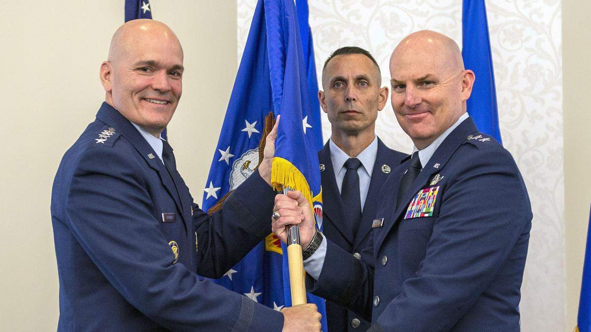 Gen. Carlton D. Everhart II, Air Mobility Command commander, passes the 18th Air Force guidon to Maj. Gen. Sam C. Barrett during a change of command ceremony Tuesday at Scott Air Force Base. Barrett assumes command from Lt. Gen. Giovanni K. Tuck.