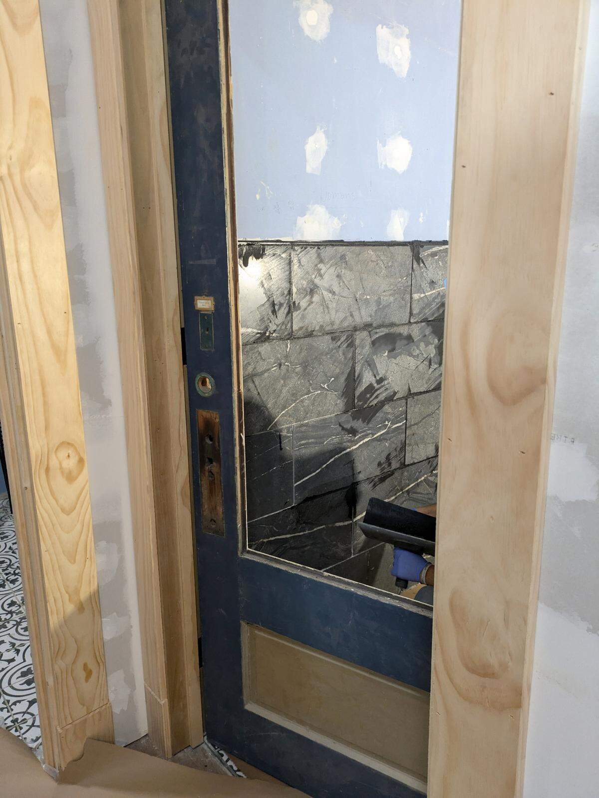 The original storefront doors have been repurposed as bathroom doors at The Harp Pub.