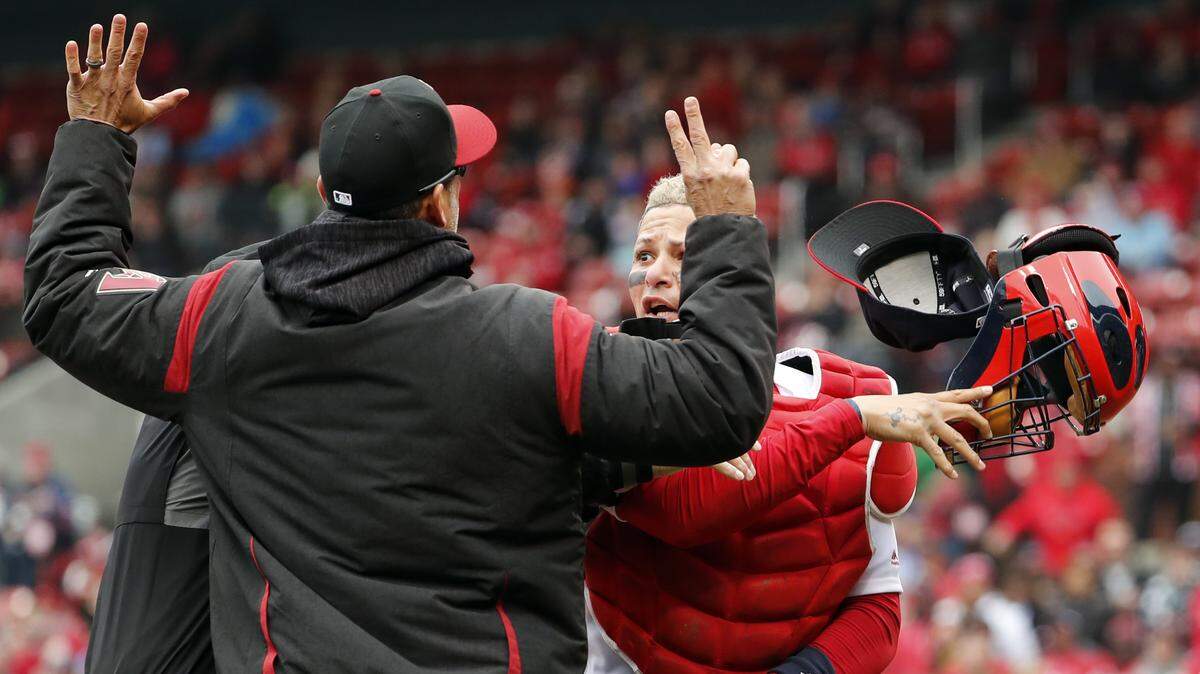 Cardinals catcher Yadier Molina, right, throws off his mask as he argues with Diamondbacks manager Torey Lovullo during an altercation in the second inning of Sunday's game. Both Lovullo and Molina were suspended for one game.