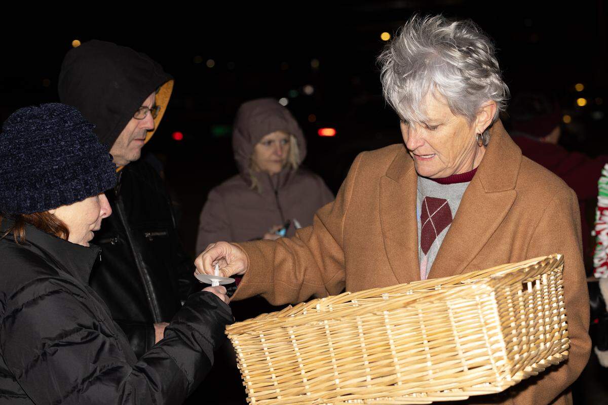 Shelly Black, volunteer services manager of Hospice of Southern Illinois, passes out candles to attendees during Tuesday’s tree lighting ceremony.