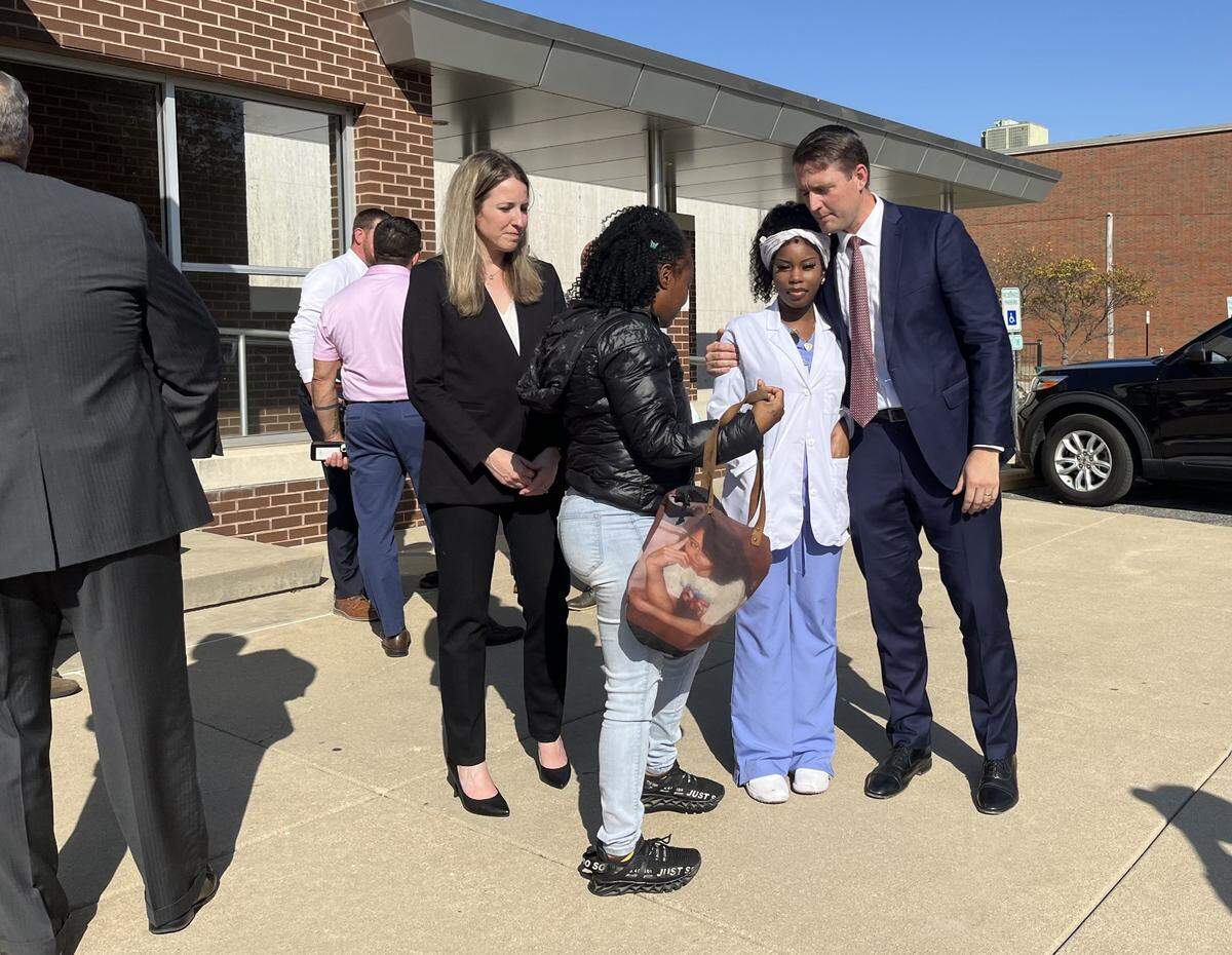 Madison County State’s Attorney Tom Haine, right, hugs Carmillya Butler on Thursday after a man was found guilty of murdering her mother, Patrenia Butler-Turner, in 2013. Assistant State’s Attorney Lauren Maricle, left, and Butler’s sister, Candace Butler-Turner, look on.