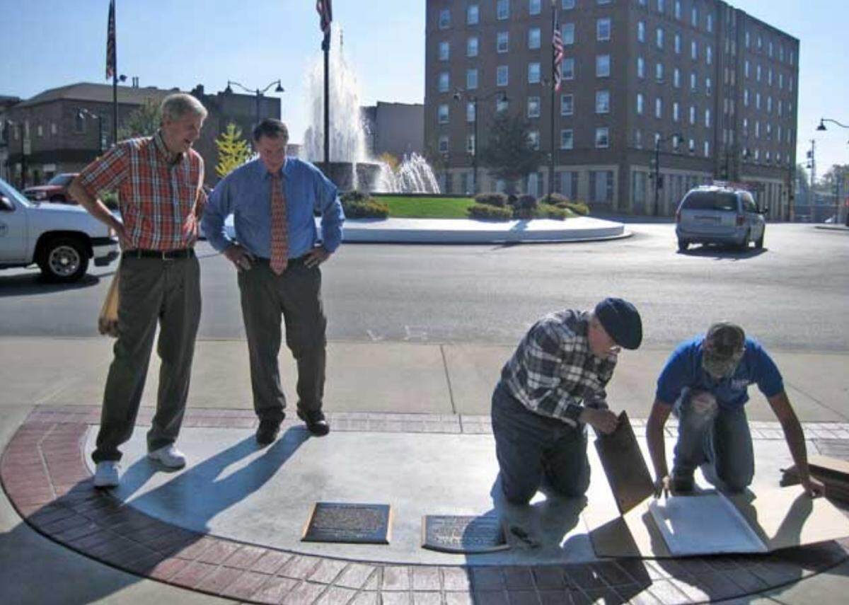 Employees of Voss Pattern Works install the first five plaques for the Belleville Walk of Fame in 2014, as Belleville Historical Society President Larry Betz, second from left, and David Braswell look on.
