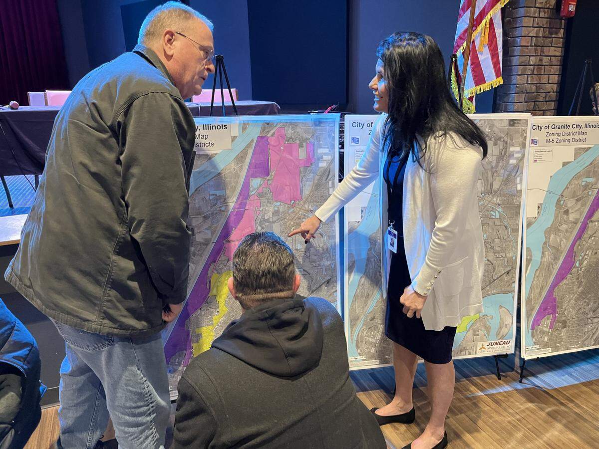 Cathy Hamilton, economic development director in Granite City, right, shows a zoning map to Ted Adams, left, and Bob Madewell after a public forum on data centers Thursday night.