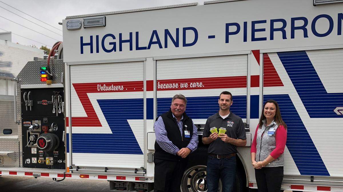 John Ludwig, president and CEO of HSHS St. Joseph’s Hospital Highland, left, and Janetta Feeny, director of emergency services for HSHS St. Joseph’s Highland and HSHS Holy Family Hospital Greenville, right, presented the two V-Watches to volunteer fireman, Eric Zobrist.